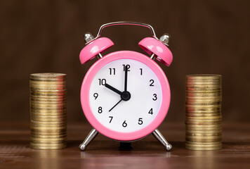 Financial planning. Save money for pension, retirement. Golden coins with alarm clock.