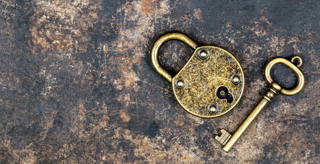 Old vintage key and padlock on a rusty grunge metal background. Escape room game banner. - 565297219