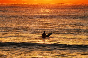 Surfers on the beach at dawn in winter.