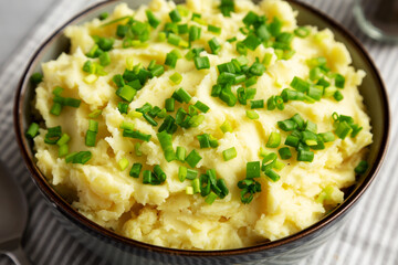 Homemade Mashed Potatoes with Chives in a Bowl, side view. Close-up.