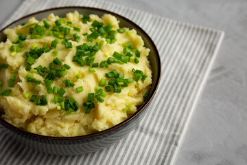 Homemade Mashed Potatoes with Chives in a Bowl, side view. Copy space.