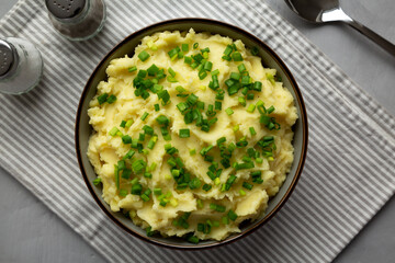 Homemade Mashed Potatoes with Chives in a Bowl, top view. Flat lay, overhead, from above.