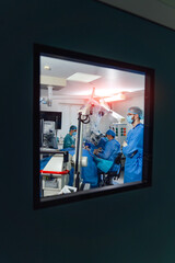 Team surgeon at work in operating room. Modern equipment in operating room. View from the window to the operating room.