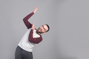 Young man standing pointing up at copy space in a studio shot - 565303015