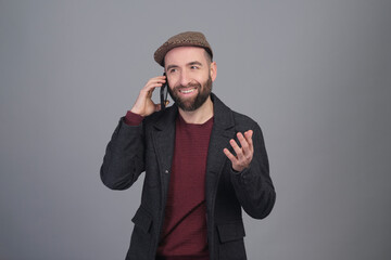 Young man speaking on the phone to the camera in a studio photo - 565303099