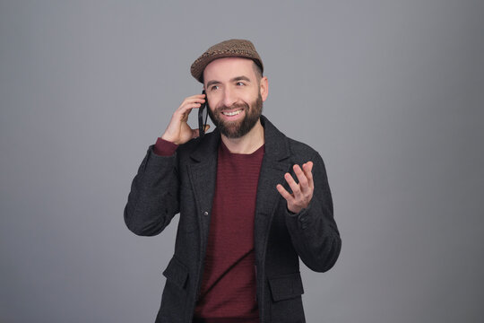 Young man speaking on the phone to the camera in a studio photo