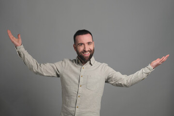 A young man raising his hands looking at the camera in a studio shot - 565303230