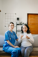 Asian female hands touching old female hand Helping hands holding bottle with pills in hands, reading instruction take care of the elderly concept.