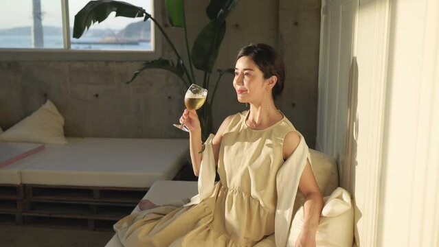 カフェのソファーに座ってビールを飲む女性	