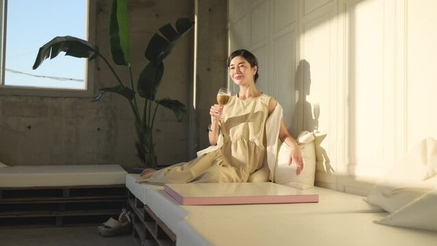 カフェのソファーに座ってビールを飲む女性	