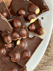 Favorite goodies. Photo of a plate with dark chocolate and nuts