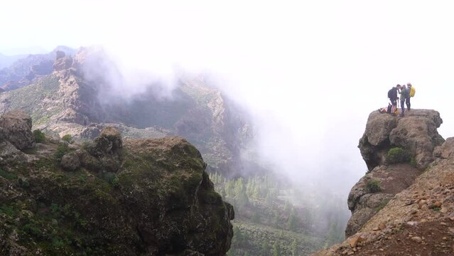 Hiking group ascending to Roque Nublo duroing a misty morning in Gran Canary Island, Spain.