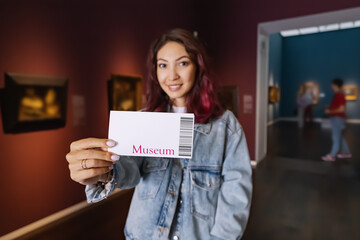 Visitor holding ticket to fine art museum with paintings. Art exhibition and entertainment - obrazy, fototapety, plakaty