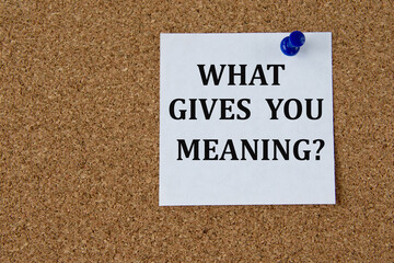 WHAT GIVES YOU MEANING? - words on a white piece of paper attached to a brown note board