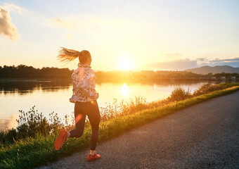 Woman running in the park. Healthy lifestyle concept, people go in sports outdoors. Silhouette family at sunset. Fresh air. Health care, authenticity, sense of balance and calmness.
