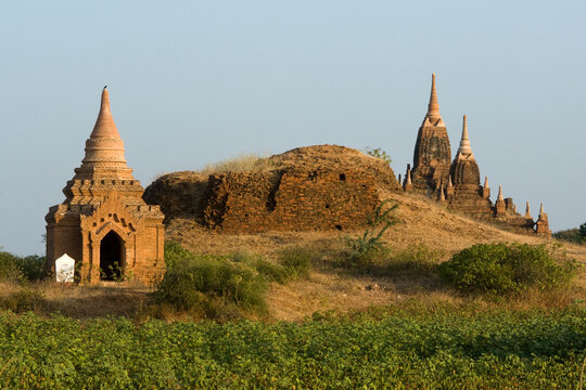 A group of 13th-century pagodas of varying sizes stand among farm fields lining the shores of the Irrawaddy river at Bagan, Union of Myanmar (Burma)