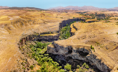 Aerial view of a Famous and popular tourist attraction of Cappadocia and Turkey - Ihlara Valley with a deep gorge and steep cliffs with hiking paths