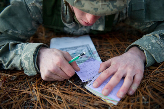 A soldier uses a map during a field training exercise.