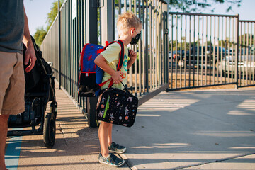 Six year old masked boy starts kindergarten during the pandemic