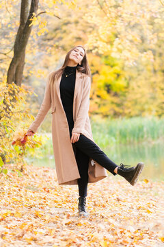 Young brunette girl walking in farest in autumn season