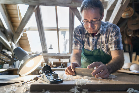Craftsman manufacturing lute at workshop