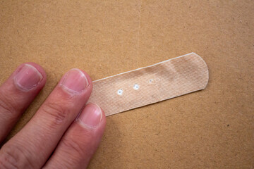 Hand holding adhesive plaster
