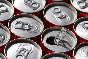 Red soda cans, top view, with one opened
