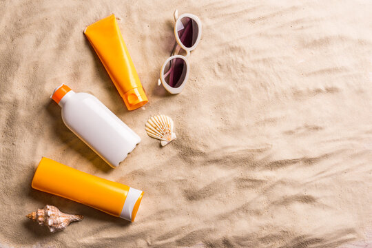 Sunblock lotion bottles on sand