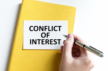 Green card on the white notepad. Text conflict of interest. Business concept