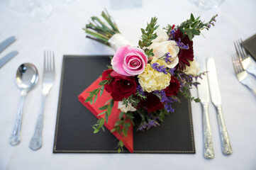 Wedding bouquet of flowers on reception table ready for evening meal and party