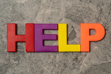 Word HELP made of colored plastic letters