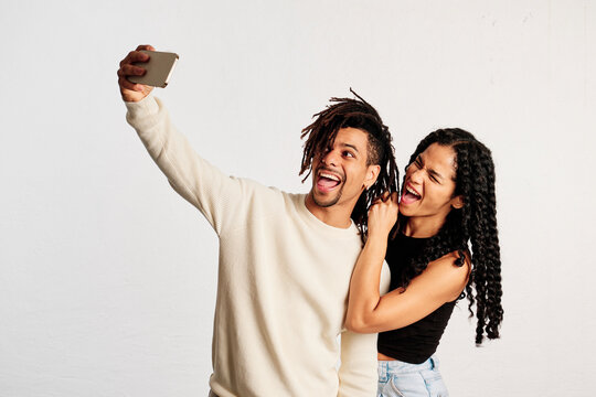 Two playful friends taking a selfie at a studio shot