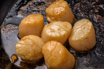 Scallops sauteed in butter, cooking in frying pan