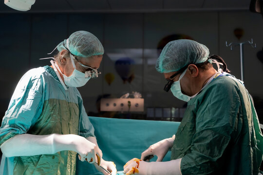 Open heart surgery, doctors and cardiologists perform open heart surgery. Doctors in green uniforms in the operating room.
