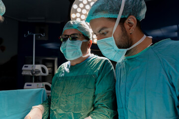 Open heart surgery, doctors and cardiologists perform open heart surgery. Doctors in green uniforms in the operating room.