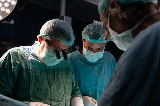 Open heart surgery, doctors and cardiologists perform open heart surgery. Doctors in green uniforms in the operating room.