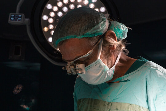 Open heart surgery, doctors and cardiologists perform open heart surgery. Doctors in green uniforms in the operating room.