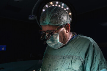 Open heart surgery, doctors and cardiologists perform open heart surgery. Doctors in green uniforms...