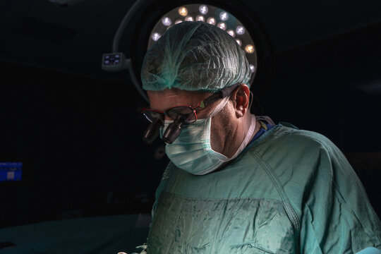 Open heart surgery, doctors and cardiologists perform open heart surgery. Doctors in green uniforms in the operating room.
