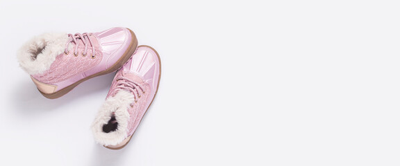 Children's pink shoes on a white background. Top view, flat lay. Banner.