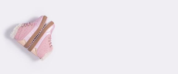Children's pink shoes on a white background. Top view, flat lay. Banner.
