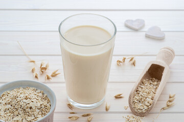 plant based oat milk in a glass, cereal grain, copy space