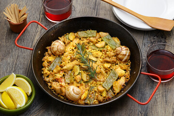 traditional Valencian paella in Spain; rabbit, chicken, garrofon beans, snails, Moroccan green beans, saffron, and bomba rice.