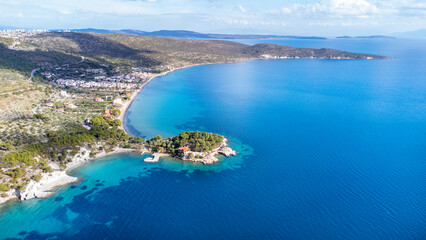 Fototapeta na wymiar Manal Bay, which is connected to İzmir, is a peaceful and quiet resting area with its deep blue sea in Mordoğan Karaburun. Aerial view with drone. Izmir - Turkey