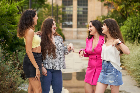 picture of young women friends talking and smiling with joy as they meet
