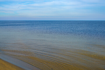 Natural background, sandy shore and water.