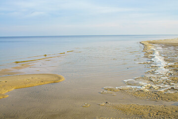 Natural background, sandy shore and water.