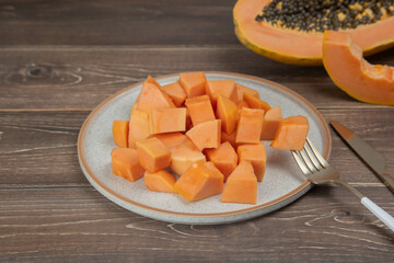 Sliced ripe papaya fruit on white plate with fork ready to eating, Tropical fruit, Top view