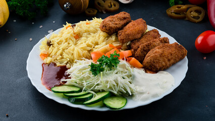 Fried chicken wings with rice, tomatoes, cabbage, cucumbers, ketchup and mayonnaise.
