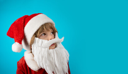 Fototapeta na wymiar Portrait of adorable boy in Santa Claus hat and beard on blue. Christmas banner